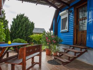une maison bleue avec une table et des bancs sur une terrasse dans l'établissement Holiday Home Blue by Interhome, à Balatonkeresztúr