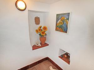 a wall with a vase of flowers and a painting at Holiday Home Casale by Interhome in Moneglia +21 photos