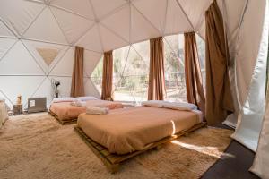 a bedroom with two beds in a tent at Glamping Miraflores in Paihuano