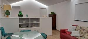 a living room with a red couch and a glass table at Casa Giulia in Castelbuono +16 photos