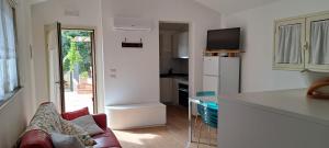 a kitchen with a white refrigerator and a couch at Casa Giulia in Castelbuono