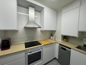 a kitchen with white cabinets and a stove top oven at Origen HARO paternina in Haro