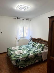 a bedroom with a bed with a green comforter and a window at Origen HARO paternina in Haro