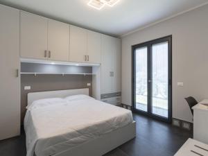 インペリアにあるApartment Rossese by Interhomeの白いベッドと大きな窓のある寝室