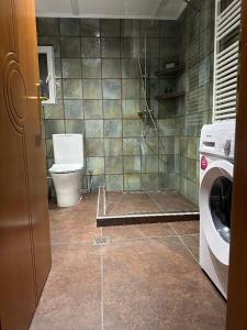 a bathroom with a toilet and a washing machine at Gardens of Babylon by Heaven's Hall in Alexandroupoli