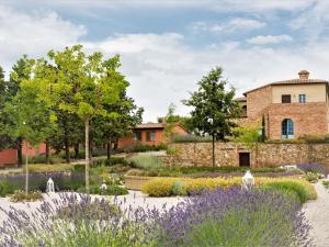a garden with purple flowers in front of a building at Apartment Cipresso by Interhome in Osteria Delle Noci
