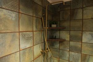 a shower in a bathroom with a tiled wall at Gardens of Babylon by Heaven's Hall in Alexandroupoli