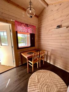 Habitación con mesa, 2 sillas y ventana en Saunamökki Iltahurri, LaatuLomat, en Telakanava