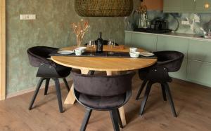 a wooden table with black chairs in a kitchen at B&B Skitter-Rent in Zwaagdijk-Oost