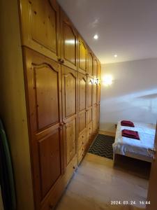 a bedroom with a bed and a wooden wall at Diós Apartman Pécs in Pécs