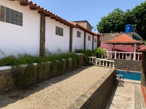 a house with a retaining wall and a swimming pool at Casa el Pozo Playa el Agua in La Loma