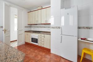 a kitchen with white cabinets and a white refrigerator at Gran Via - 1 in Barcelona