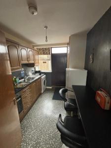 a small kitchen with a sink and a refrigerator at Taise Veiw in Ballycastle