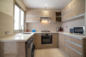 a kitchen with a stove and a dishwasher at Luxury Seafront Apartment 101sqm with 2 Bedrooms and Wi-Fi Unlimited in Agadir