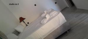 a bed with white sheets and towels on it at Evestudioskos in Kos Town