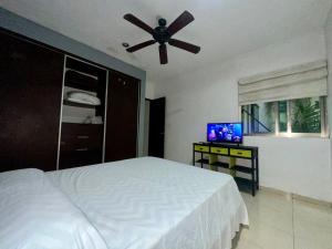 une chambre avec un lit et un ventilateur de plafond dans l'établissement Casa en el corazón de Playa del Carmen, à Playa del Carmen