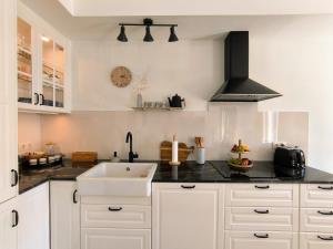 eine Küche mit weißen Schränken und einer Spüle in der Unterkunft Limun House in Zaton