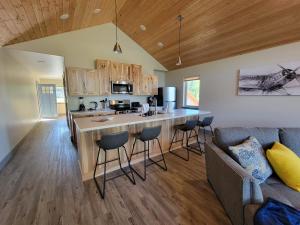 a kitchen and living room with a counter and a couch at Lakeshore Lodging Suites in Homer