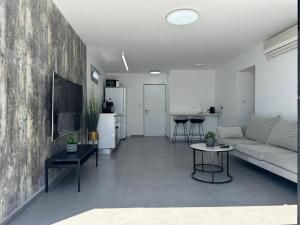 a living room with a couch and a table at מיני דירת פנטהאוז in Rishon LeẔiyyon