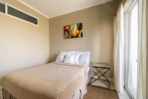 a bedroom with a bed with a glass table next to a window at Choose To Be Happy at Brompton Estates - One and Two Bedroom with Pool in Kingston