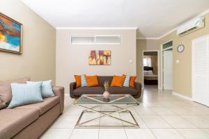a living room with a couch and a table at Choose To Be Happy at Brompton Estates - One and Two Bedroom with Pool in Kingston