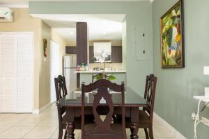 a dining room with a table and a kitchen at Choose To Be Happy at Brompton Estates - One and Two Bedroom with Pool in Kingston