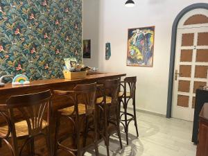 a bar with chairs and a wall with a painting at Green House in Avola