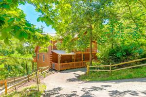 a cabin in the woods with a fence around it at Owls Nest Pet-Friendly Cabin with Private Hot Tub in Ranger