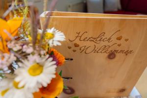 een houten bord met bloemen in een vaas bij Gutzingerhof in Bad Kleinkirchheim