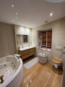 un bagno con vasca, lavandino e WC di Maison avec plan d'eau a Saint-Gervais-du-Perron