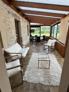 un soggiorno con mobili bianchi e tavolo di Maison avec plan d'eau a Saint-Gervais-du-Perron