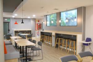a bar in a restaurant with tables and chairs at Holiday Inn Express Madrid-San Sebastian de los Reyes by IHG in San Sebastián de los Reyes