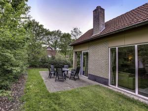 a patio with chairs and tables in a yard at Holiday Home Buitenplaats Gerner-5 by Interhome in Dalfsen