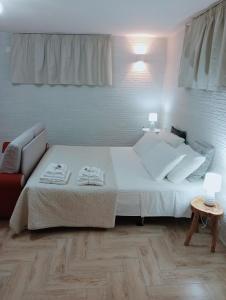 a bedroom with a white bed and a couch at L'alloggio delle vacanze estive in Corsano