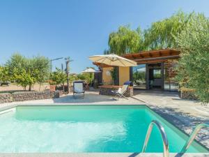 a swimming pool with an umbrella and a house at Chalet Il Vitigno by Interhome in Sutri