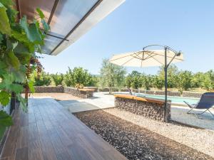 an outdoor patio with a bench and an umbrella at Chalet Il Vitigno by Interhome in Sutri