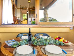 Una mesa de madera con dos platos y una botella de vino. en Apartment Ginepro by Interhome, en Costa Paradiso