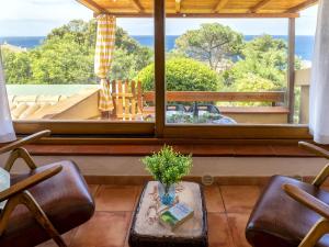 Una sala de estar con una mesa y sillas y una gran ventana. en Apartment Ginepro by Interhome, en Costa Paradiso