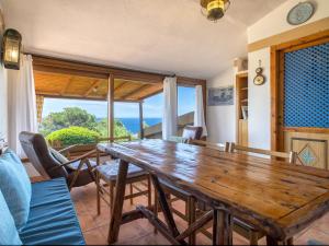 comedor con mesa de madera y vistas al océano en Apartment Ginepro by Interhome, en Costa Paradiso 30 fotos más