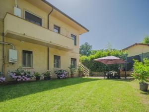una casa con sombrilla y patio de hierba en Holiday Home Gerry House by Interhome, en Camaiore