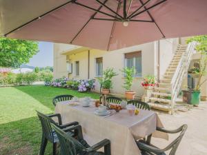 Una mesa y sillas con una sombrilla en un patio. en Holiday Home Gerry House by Interhome, en Camaiore