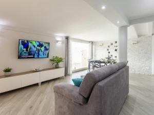 salon z kanapą i telewizorem na ścianie w obiekcie Villa Elena by Interhome w mieście Trappeto