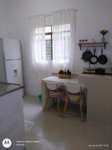 クーニャにあるChale na natureza dentro pousada pedacinho do ceuのテーブルと椅子2脚、冷蔵庫付きのキッチン +29枚の写真