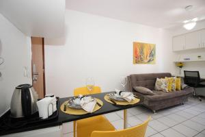 a kitchen and living room with a table and a couch at OZPED Flats Particulares Condomínio Mont Serrat in Brasilia