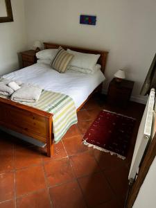 una camera da letto con un letto grande con struttura in legno di Maison de campagne du XVIIe siècle a Lammerville