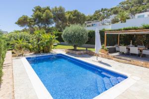 a swimming pool in a villa with a garden at La Lunita in Santa Eularia des Riu