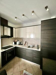 a kitchen with white cabinets and a sink at Apartments Nirgilija in Tivat