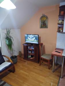 a living room with a flat screen tv and a table at Parovic in Nevesinje