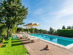 a swimming pool with lounge chairs and an umbrella at Holiday Home Sea View by Interhome in Castelnuovo della Misericordia