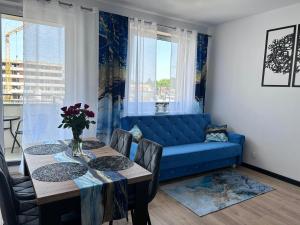 a living room with a blue couch and a table at A&R Apartamenty Wenedów II, Parking prywatny, darmowe Wi-Fi in Koszalin